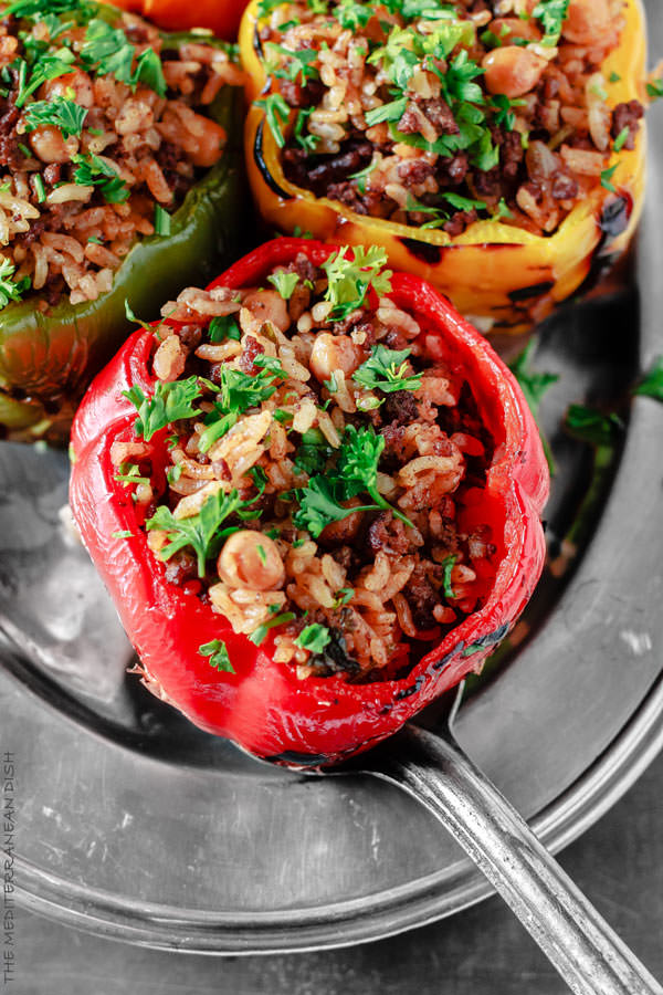 Mediterranean Stuffed Peppers Recipe | The Mediterranean Dish. Easy, delicious, stuffed peppers recipe with step-by-step tutorial. The gluten free Mediterranean-style stuffing with rice, chickpeas and spiced ground beef is a favorite! See the full recipe on TheMediterraneanDish.com