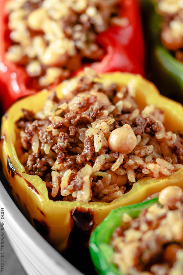 Mediterranean Stuffed Peppers Recipe | The Mediterranean Dish. Easy, delicious, stuffed peppers recipe with step-by-step tutorial. The gluten free Mediterranean-style stuffing with rice, chickpeas and spiced ground beef is a favorite! See the full recipe on TheMediterraneanDish.com