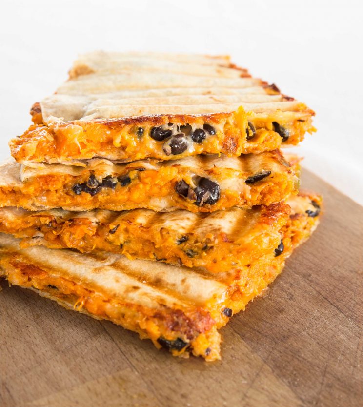 Stacked Roasted Sweet Potato and Black Bean Quesadillas on chopping board
